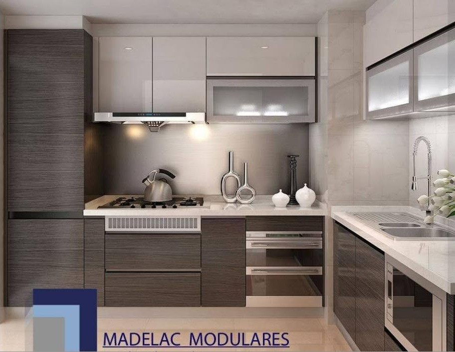 Cocina moderna en L con muebles en madera gris, alacenas blancas brillantes y mesón blanco, con el logo de Madelac modulares