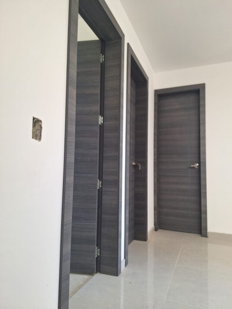 Pasillo con puertas internas en madera gris y marcos a juego