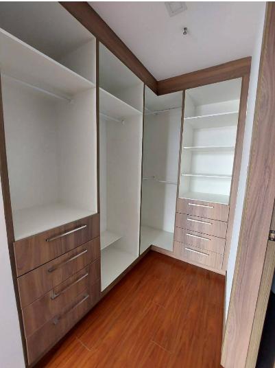 Walk-in closet en madera y blanco con colgadores, repisas y cajoneras