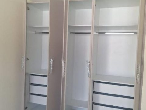 Closet abierto con colgadores, repisas y cajoneras