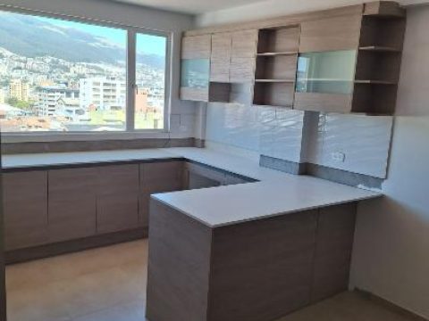 Cocina en L en madera gris con península y ventanal con vista a Quito