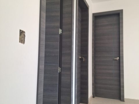 Pasillo con puertas internas en madera gris y marcos a juego