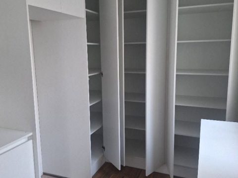Vestidor blanco con puertas altas y repisas de piso a techo